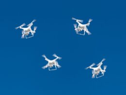 A drone swarm flying in a blue sky