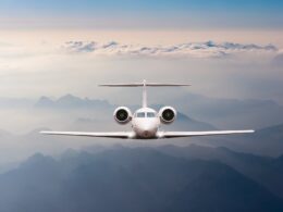 Airplane fly over clouds and Alps mountain on sunset Front view of a big passenger or cargo aircraft business jet airline